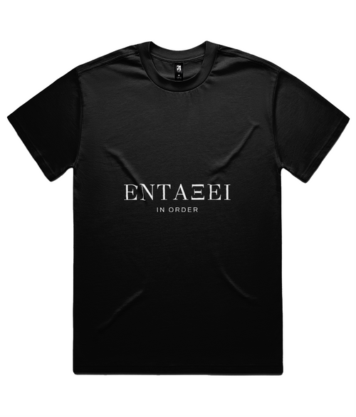 Black ΕΝΤΑΞΕΙ Tee shown flat on white, front print: ΕΝΤΑΞΕΙ hand-set across the chest in Didot capitals with IN ORDER beneath.