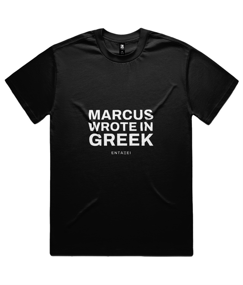 Black Marcus Wrote In Greek Tee shown flat on white, front print: MARCUS WROTE IN GREEK in three lines of heavy sans capitals with the ΕΝΤΑΞΕΙ wordmark beneath.