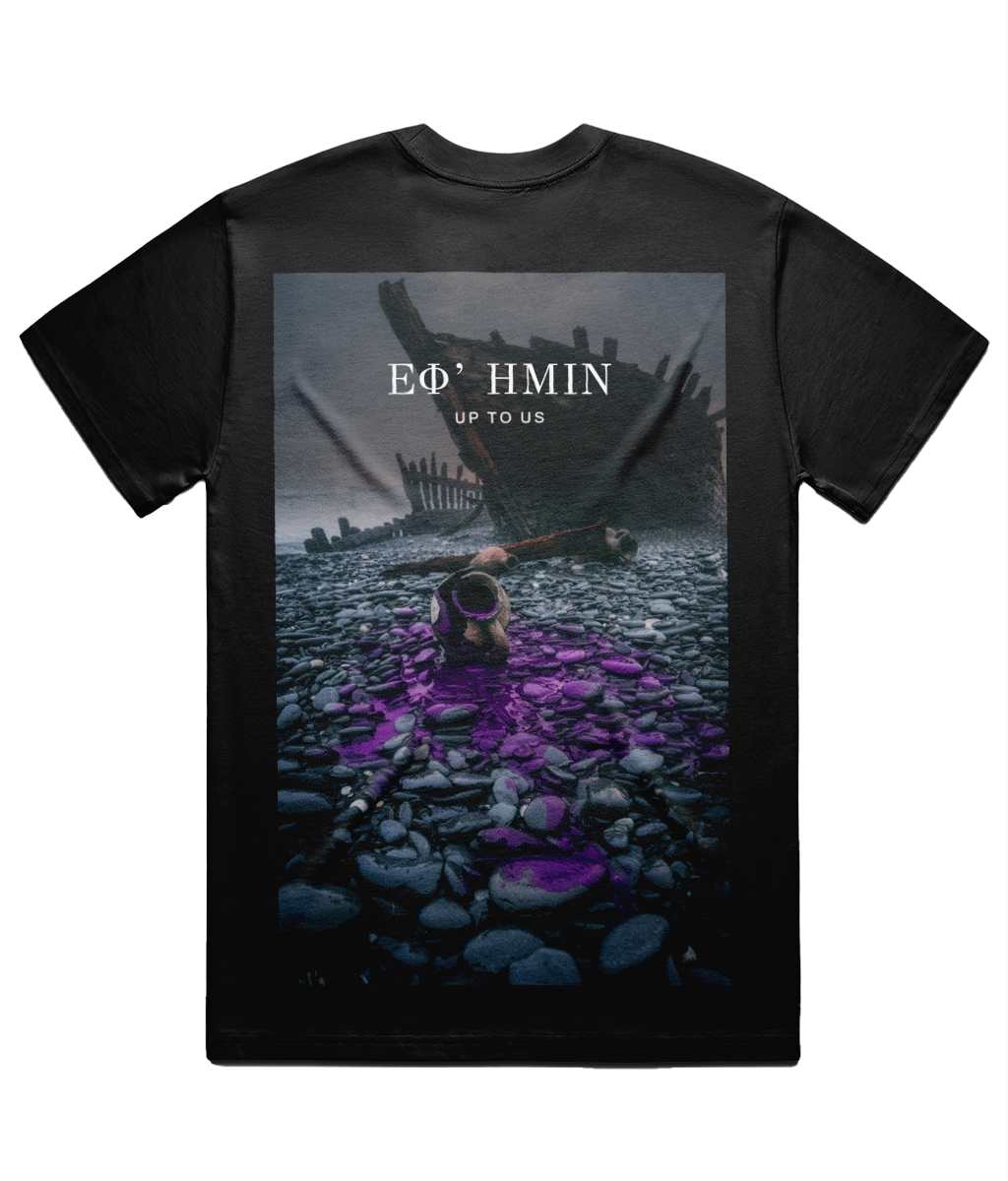 Black Citium Tee shown flat on white from the back, full back print: a storm beach at dawn with a wrecked hull and one cracked jar leaking purple dye, ΕΦ’ ΗΜΙΝ set above it in Didot with UP TO US beneath.