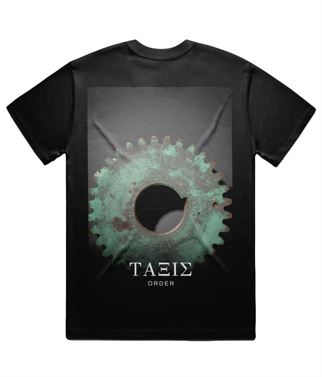 Black ΤΑΞΙΣ Tee shown flat on white from the back, full back print: a single verdigris-green ancient bronze gear wheel, with ΤΑΞΙΣ set in Didot beneath it and ORDER below that.